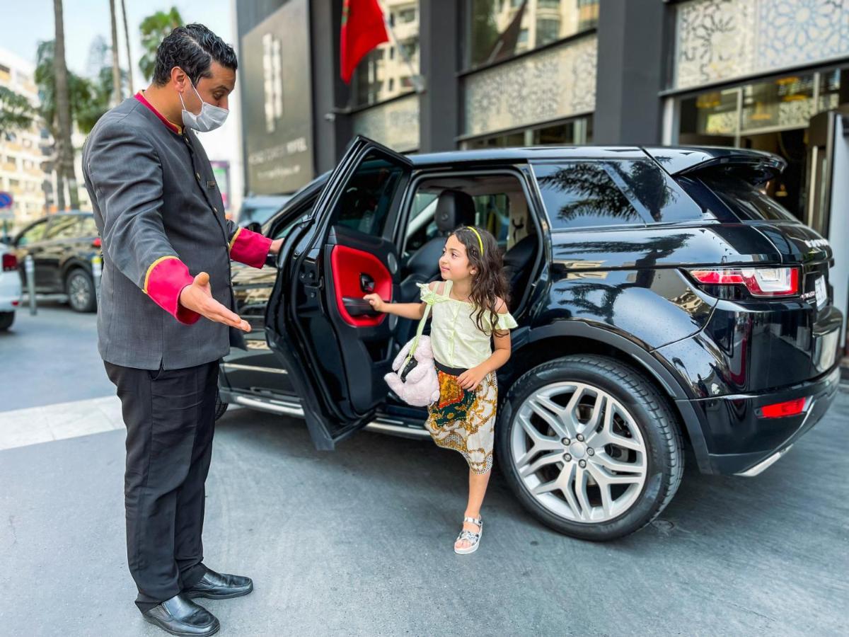 Kenzi Tower Hotel Casablanca Bagian luar foto A valet opening a car door for a young girl